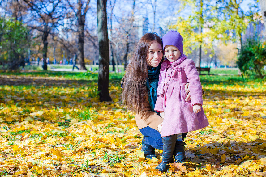 小可爱女孩和年轻母亲 在阳光明媚的日落公园图片