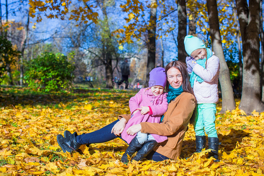 年轻母亲和美丽的女儿 在秋天的温暖阳光明媚的天气中 在秋公园图片