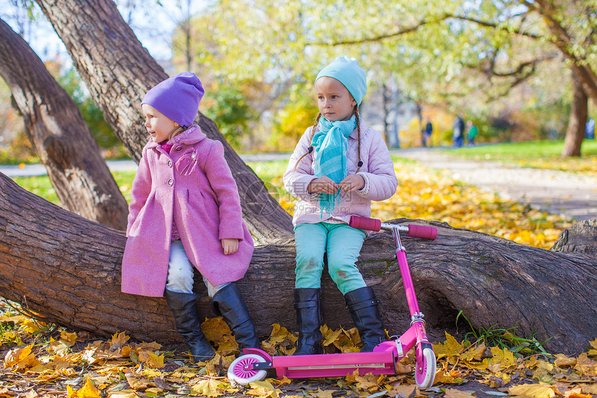 秋天公园的骑摩托车的小美女孩儿婴儿姐姐家庭孩子草地树木微笑叶子父母森林图片