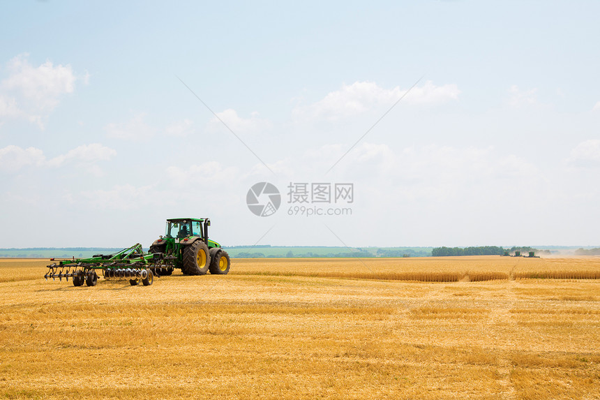 在字段中带有栽培器的拖拉机土壤收成机械车辆粮食工作草地栽培机器平原图片