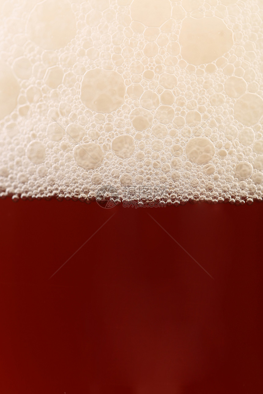 靠近啤酒与泡沫发泡泡沫状白色气泡干杯玻璃酒吧棕色饮料图片