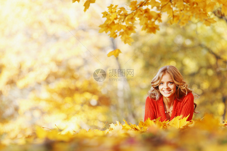 女人躺在秋叶上金子叶子微笑金发女孩幸福喜悦橙子女性森林图片