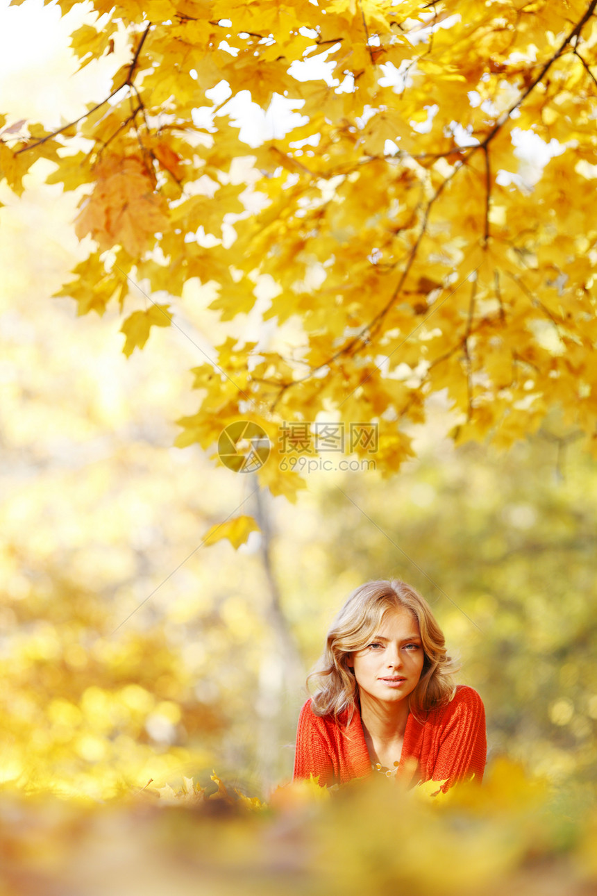 女人躺在秋叶上女孩女性金发森林微笑快乐幸福红色橙子乐趣图片