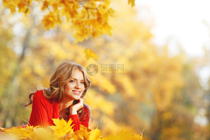 女人躺在秋叶上叶子幸福女孩橙子森林微笑金子快乐公园女性图片