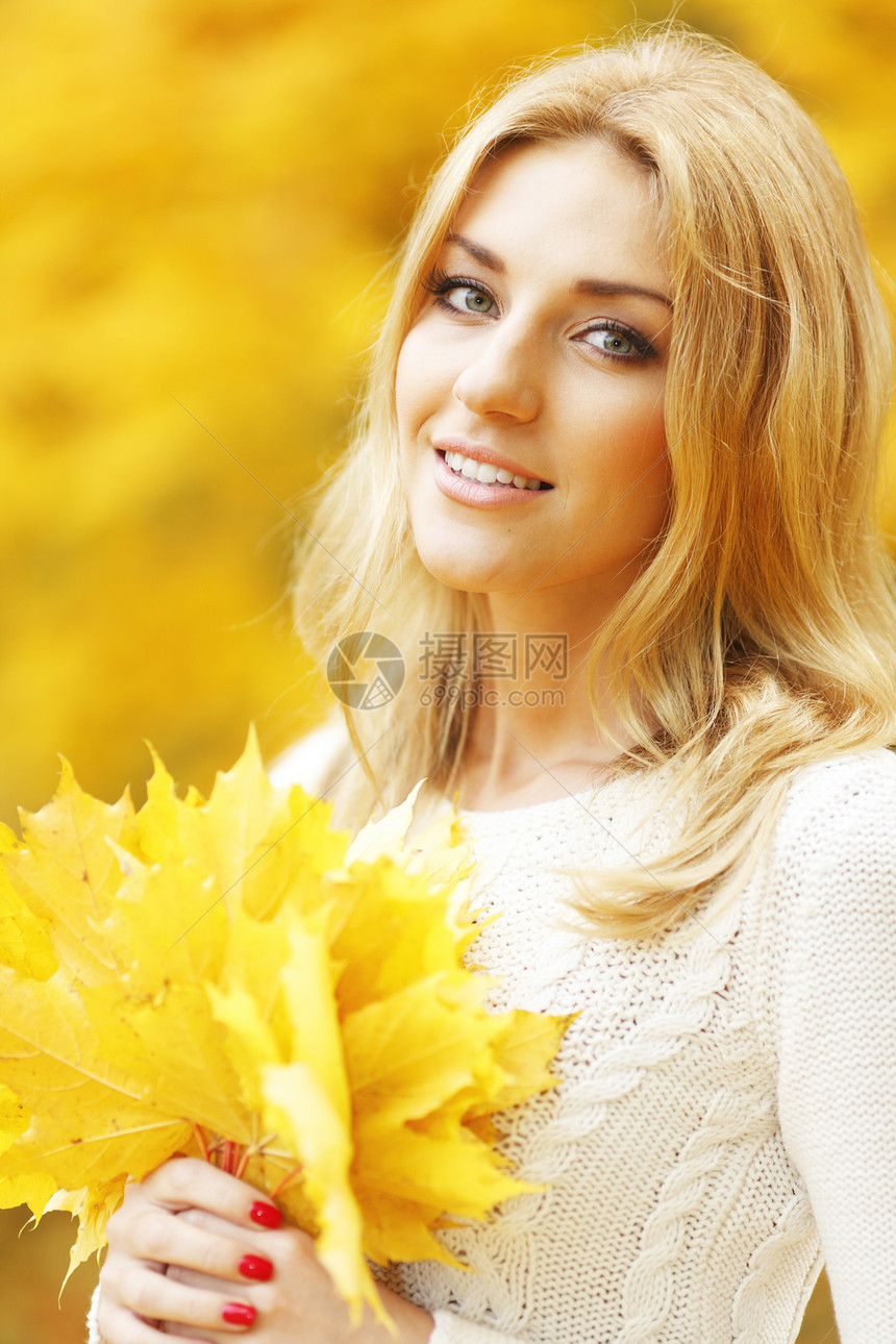 秋天公园中微笑的女人白色毛衣黄色季节女性叶子公园女孩金发女士图片