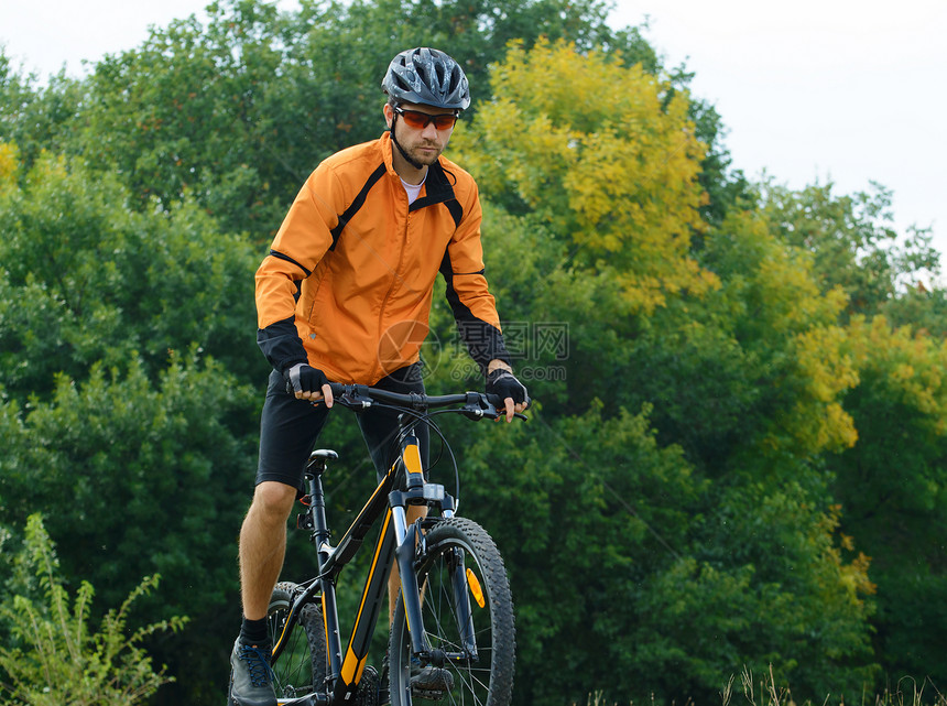 赛车员在美丽的秋季森林中骑自行车车轮运动橙子速度锻炼爬坡竞赛男生蓝色下坡图片