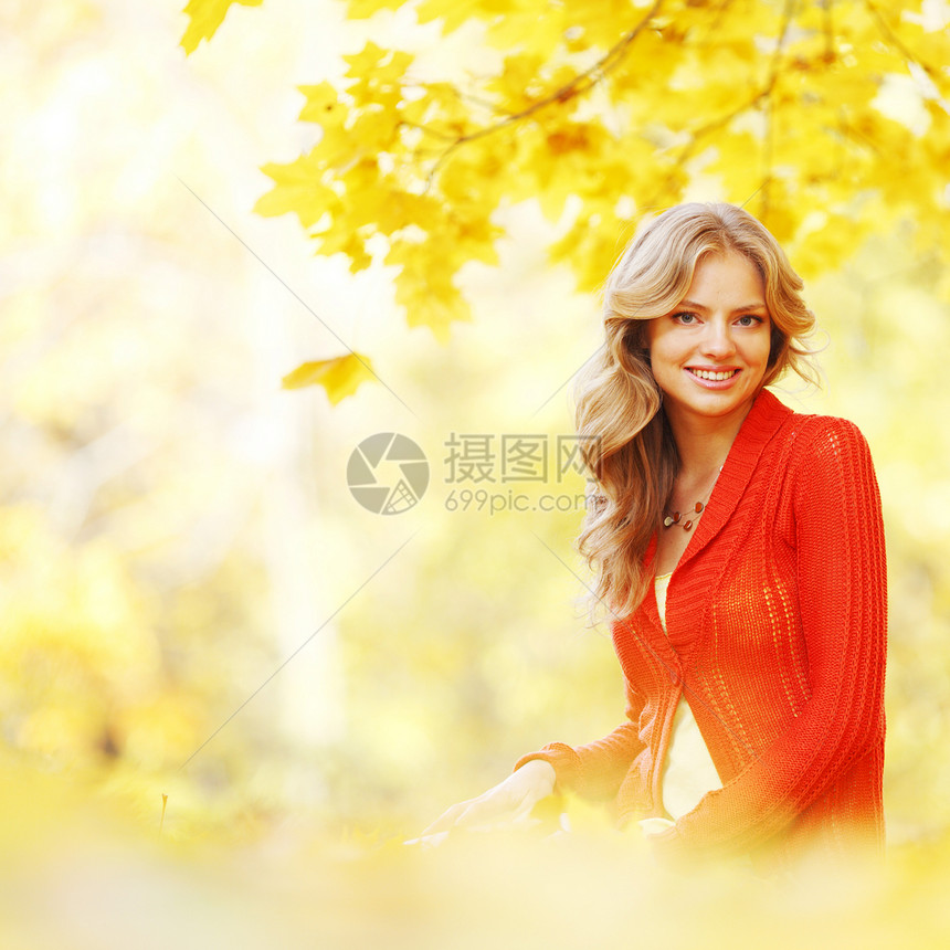 妇女坐在秋叶上乐趣喜悦女性森林幸福橙子红色微笑女孩叶子图片