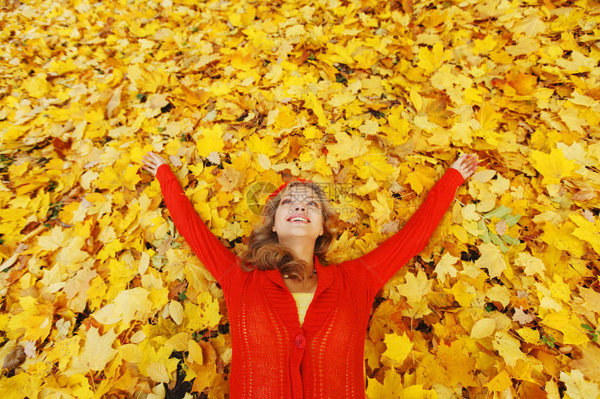 女人躺在秋叶上幸福红色喜悦女孩微笑叶子森林女性快乐橙子图片