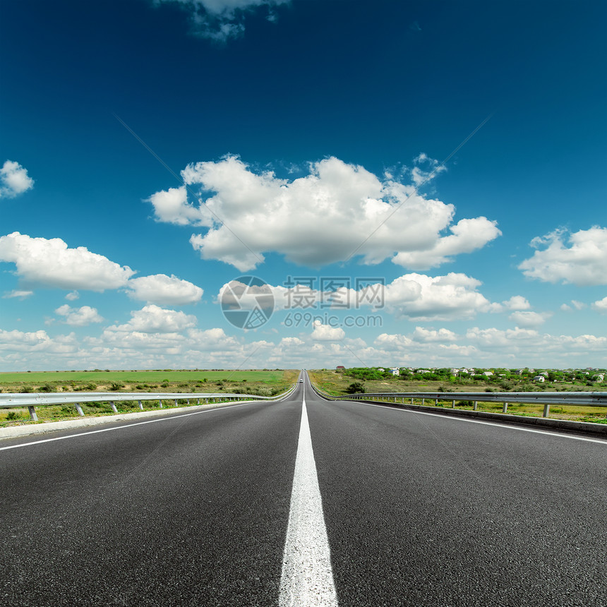 沥青路上的深蓝色云层天空图片