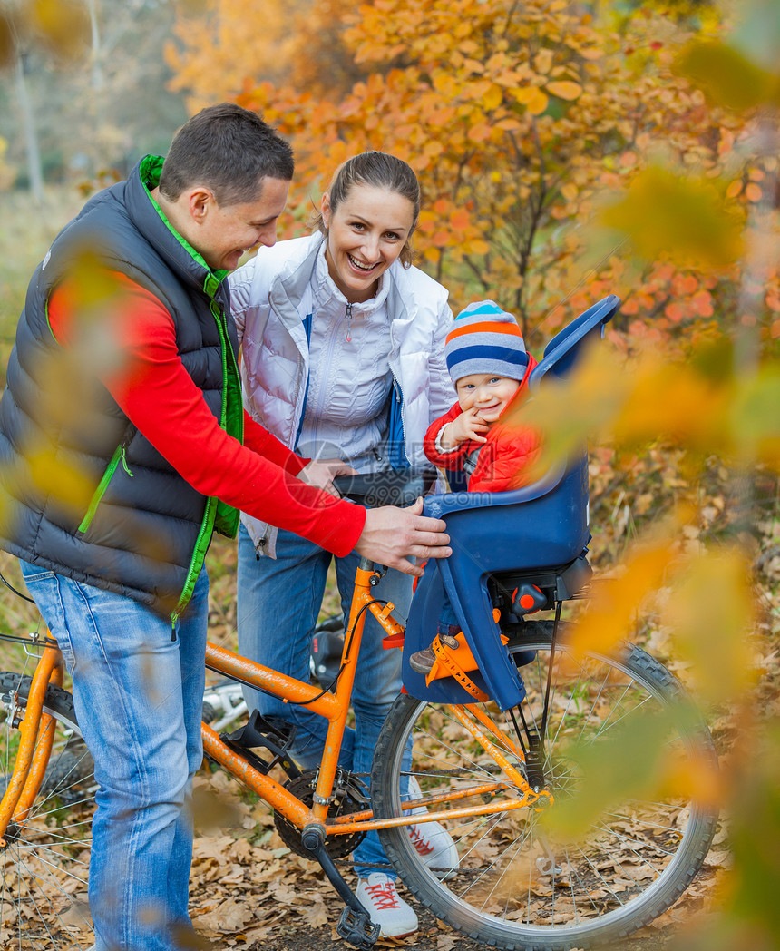家庭有婴儿骑自行车女孩幸福乐趣父亲女士儿子活动头盔骑术男性图片
