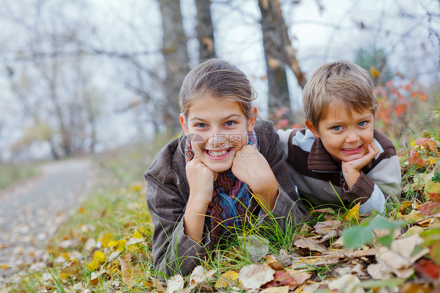 秋天公园的孩子孩子们太阳叶子季节乐趣童年晴天女孩男生树叶图片