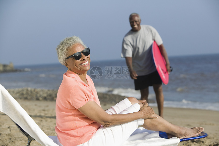 中年妇女坐在沙滩的甲板椅上图片