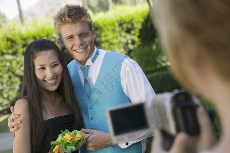 穿着穿好衣服的青少年夫妇在校外舞蹈表演录像机背景图片