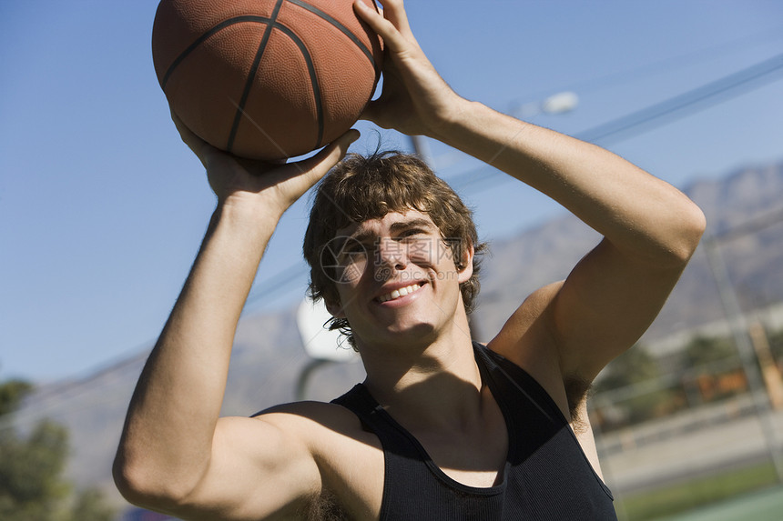 快乐的年轻人 用篮球打罚球图片