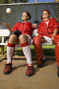 两个年轻的棒球选手 坐在长椅上坐着看球场高清图片