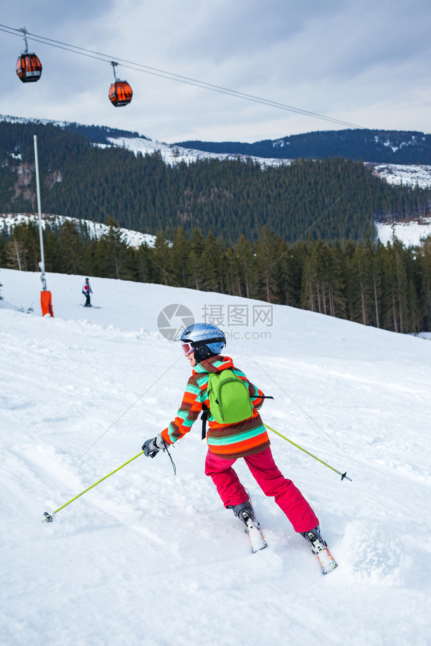 女孩在滑雪板上运动孩子们滑雪者头盔娱乐活动季节自由晴天背光图片
