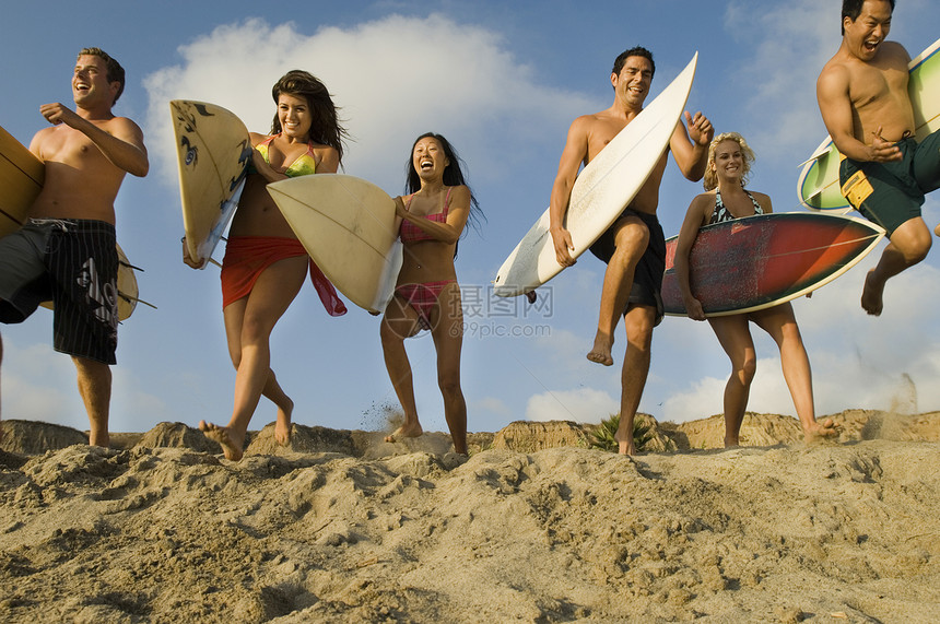 一群多族裔朋友 在沙沙滩上摆布冲浪板男士青少年拉丁闲暇跑步海滩男人种族女性团体图片