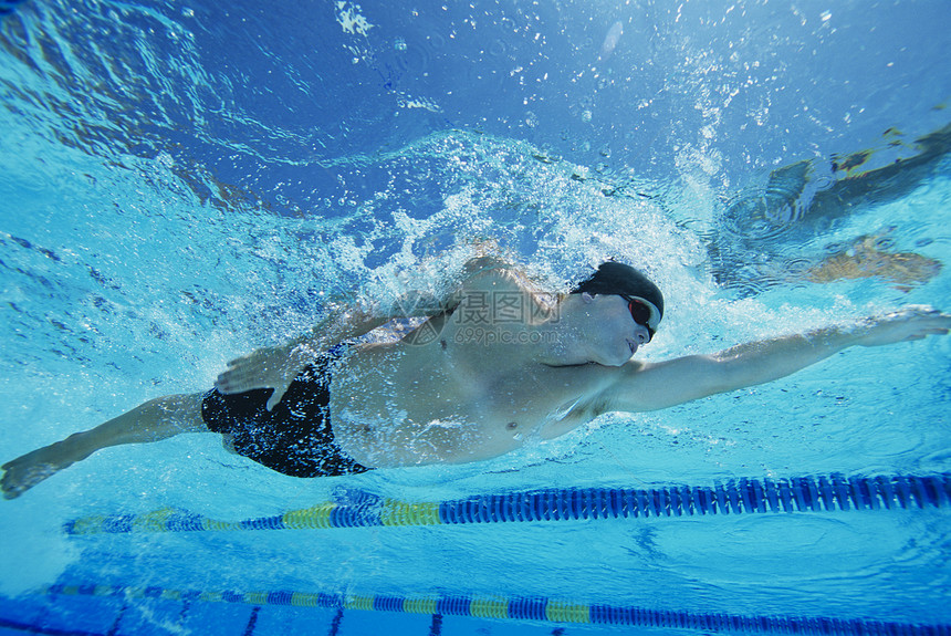 一个在水下游泳的年轻人的低角度视角游泳池头饰活力男子摄影水池精力全身竞技中年图片