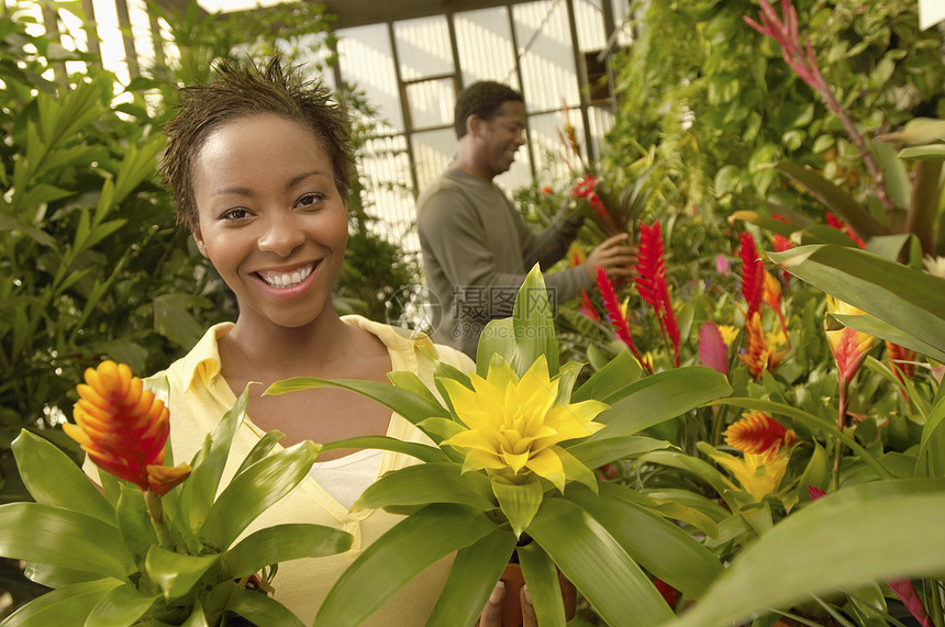 一个快乐的非洲裔美国女人的肖像 男人在植物园里背景上的男人图片