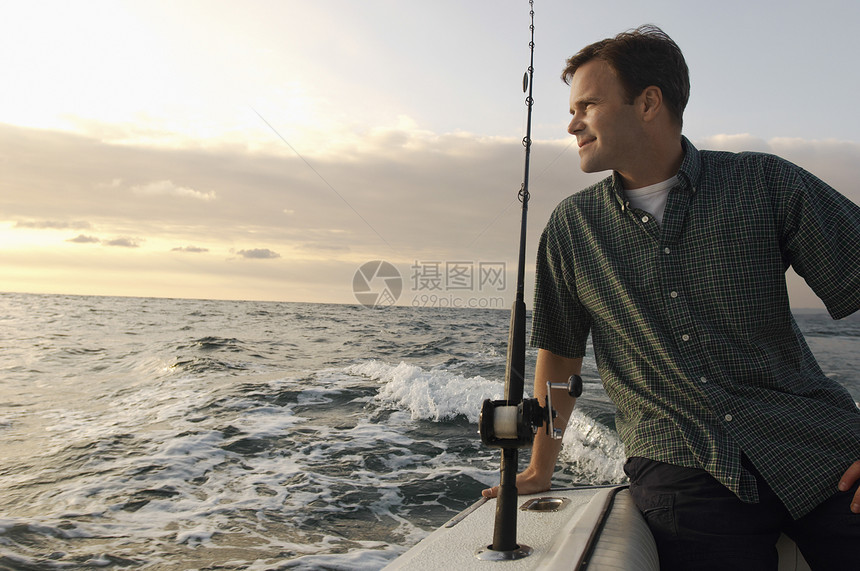 休闲男子在海上游艇上捕鱼图片