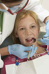牙科器材一名女牙医在诊所接受检查的少女背景