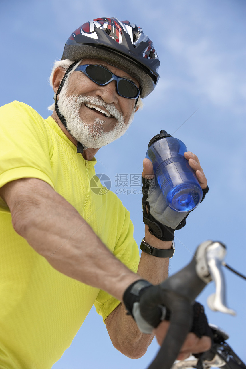 高级男性双骑自行车男子持有水瓶的肖像图片
