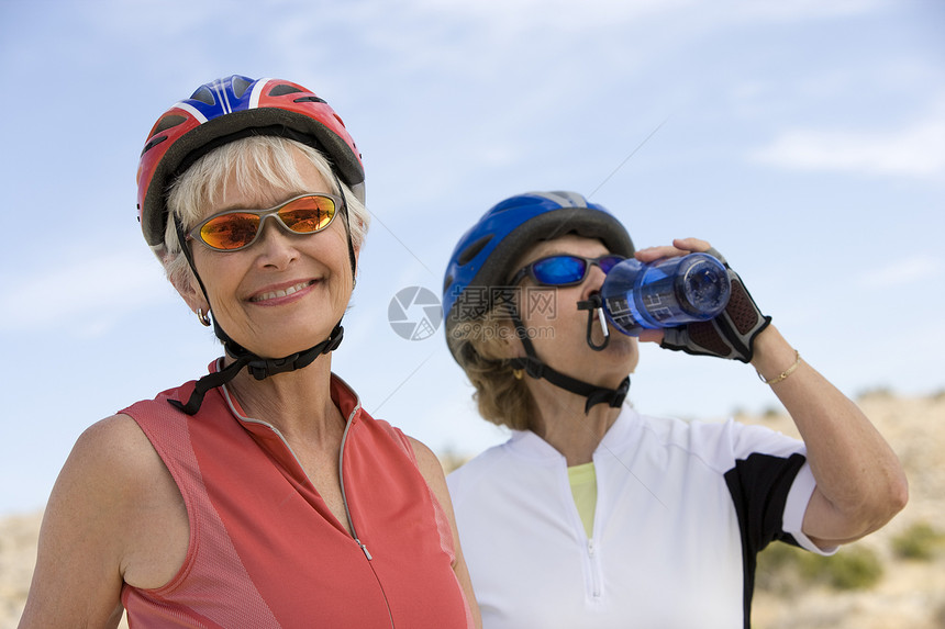 一位快乐的年长女人的肖像 朋友饮用水在背景中图片