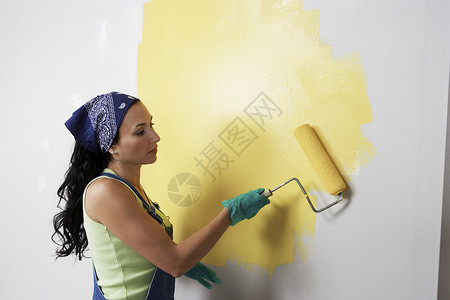 墙上涂黄漆的滚滚女人侧面视图背景图片