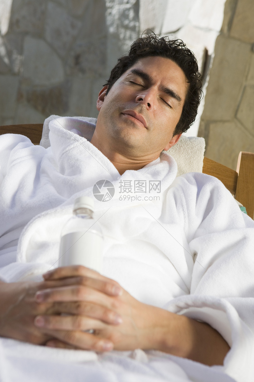 穿着浴袍的成熟男子睡在椅子上图片