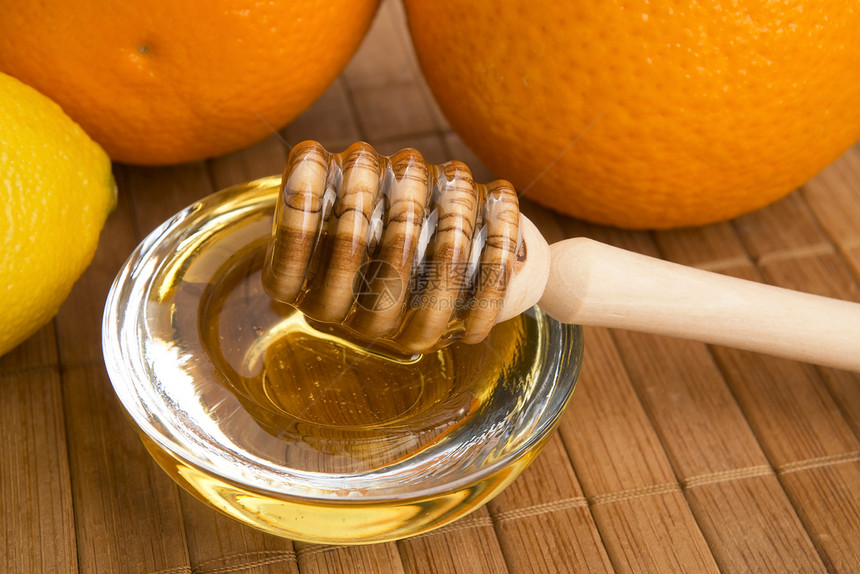 含柠檬和橙子水果的新鲜蜂蜜金子生活方式食物液体餐具健康饮食甜食美食家黄色玻璃图片