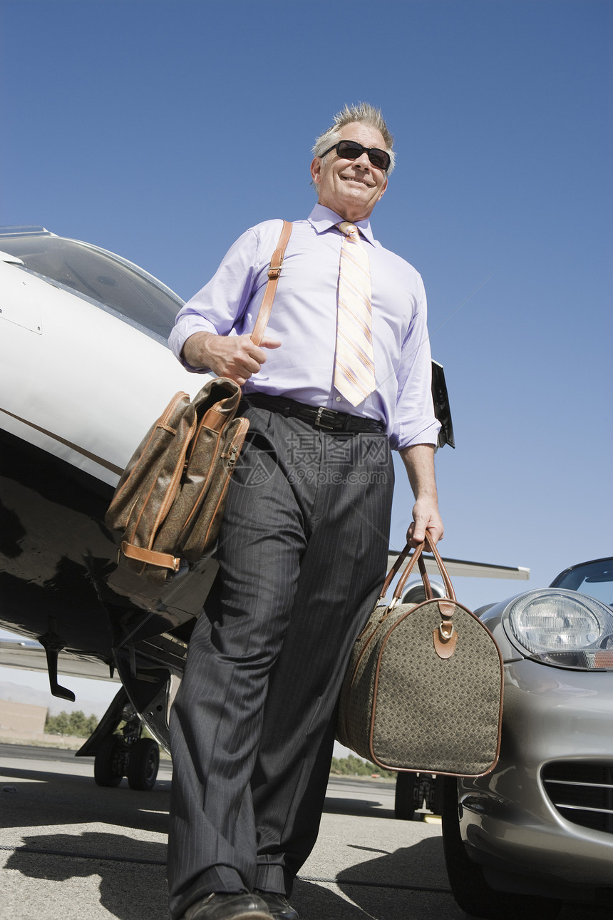 高级商务人士携带行李在机场行走的低角度视角视野图片