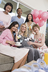 参加婴儿淋浴的妇女微笑腹部气球怀孕活动女性庆典服装倾斜女士背景图片