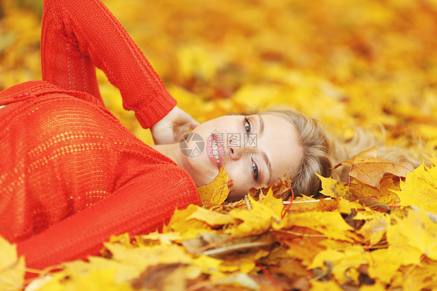 女人躺在秋叶上公园喜悦金子叶子女性女孩橙子幸福微笑快乐图片