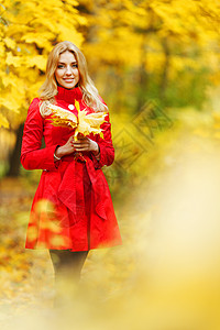 拿着叶子女孩秋季妇女公园叶子橙子女性金发黄色红色女孩微笑背景