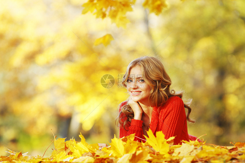 女人躺在秋叶上橙子森林女孩微笑金子红色乐趣叶子公园幸福图片