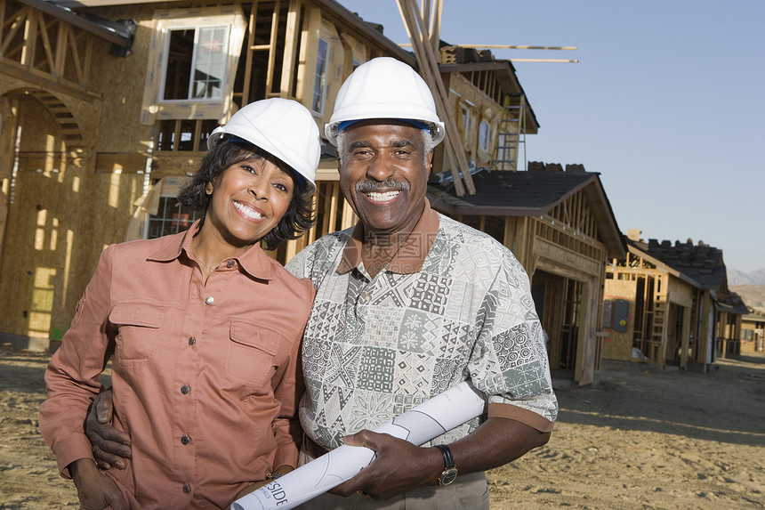 喜悦的非洲裔美籍老人情侣肖像 在正在建造的房子前有蓝图图片