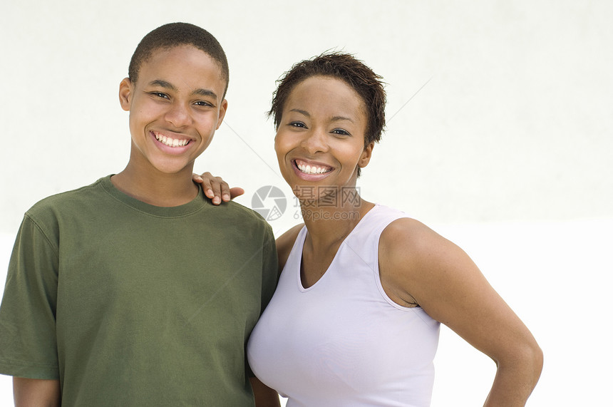 快乐的非裔美国人母亲和儿子在白色背景下站在一起的肖像 (笑声)图片