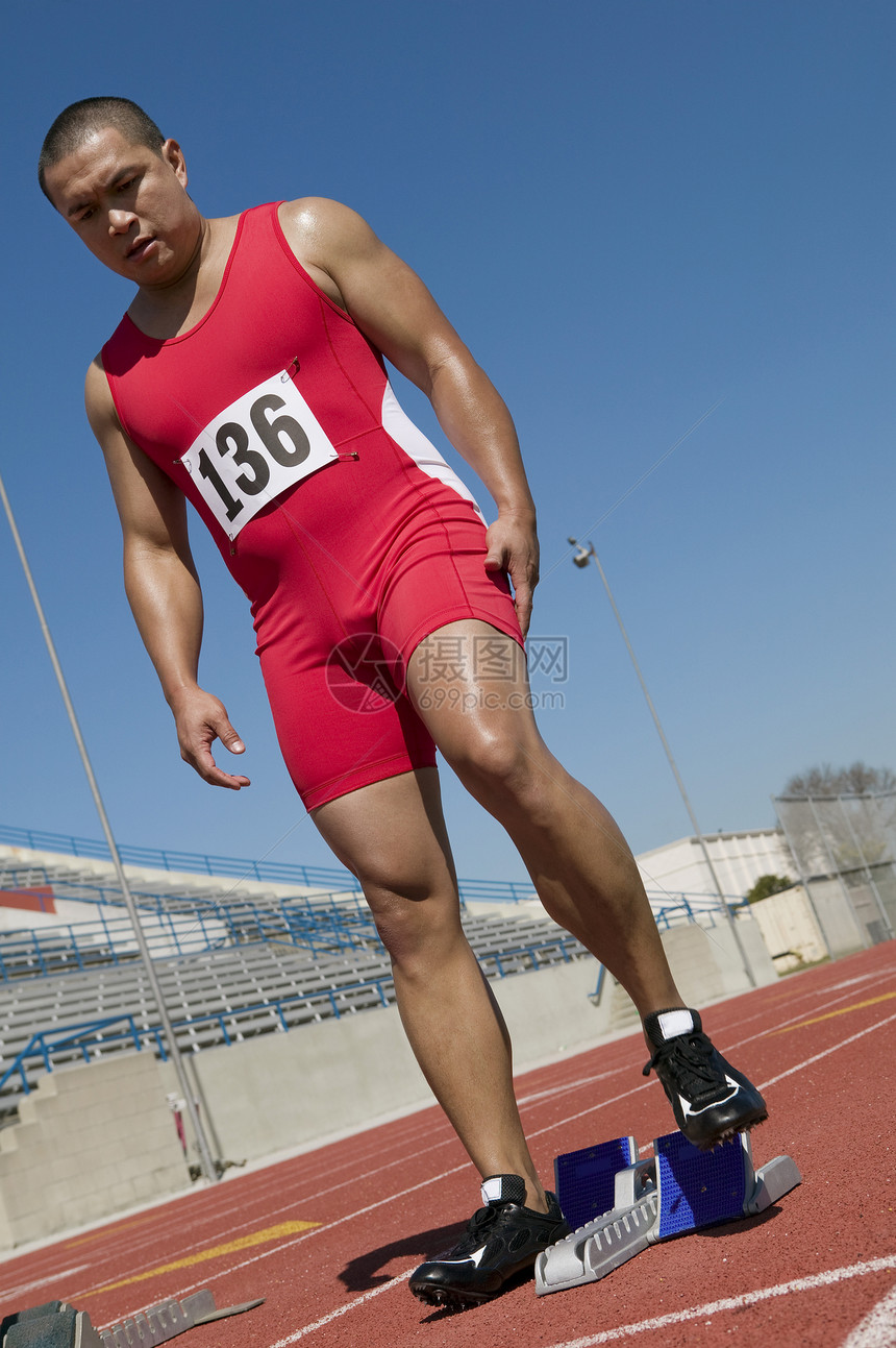 在赛道上起跑线的成年男性运动员全年图片