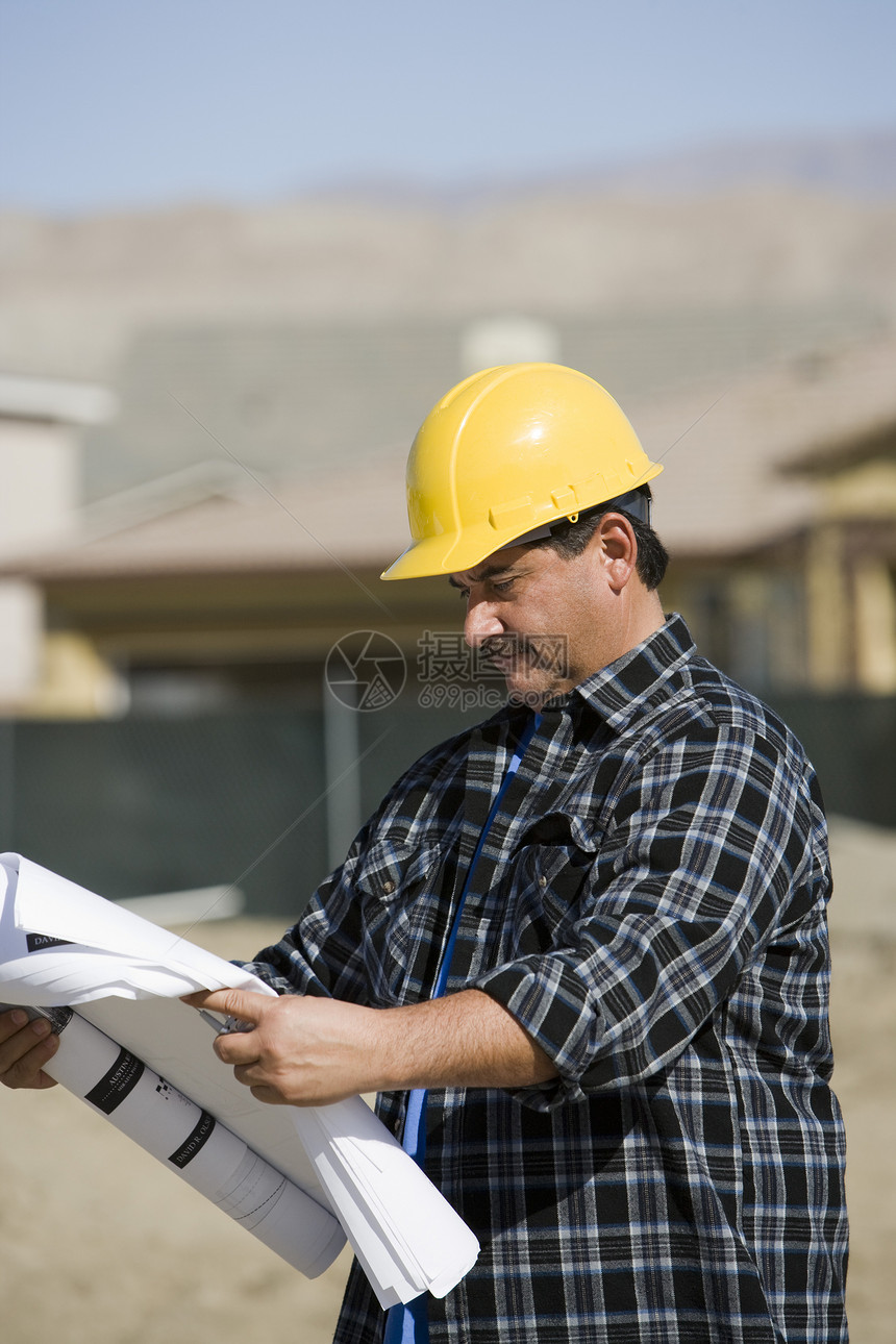 负责审查蓝图的成熟男性建筑施工工人;图片