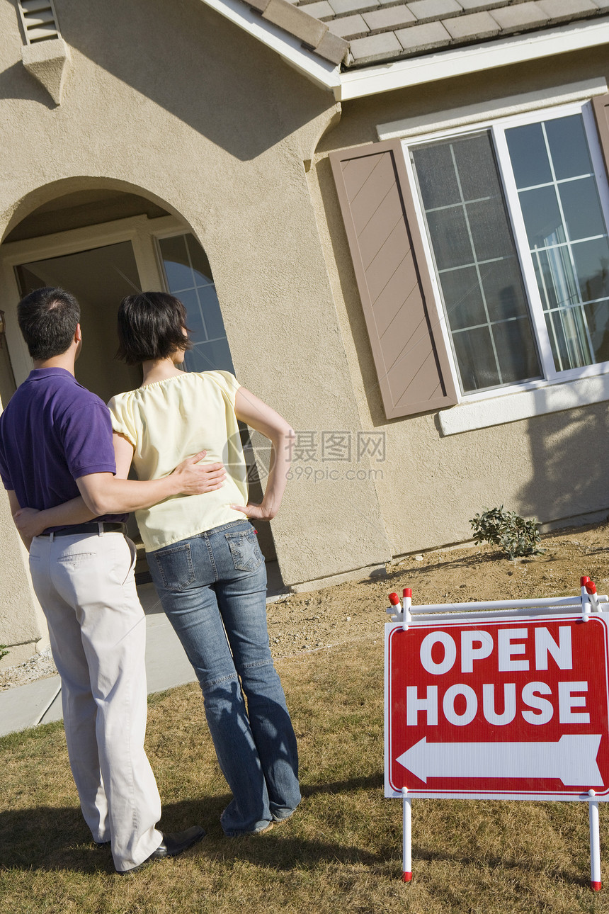 看见一对成熟夫妇站在房子外 有开放房屋标志板的成人夫妇图片