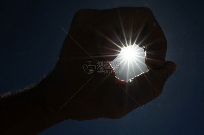 一只手在蓝色背景上捕捉太阳星星耀斑星星反射天空手指上帝活力精神自由幸福图片