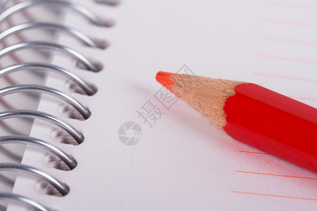 缤纷螺旋笔记本上的红色笔记本办公室记事本艺术绘画铅笔活页写作宏观素描文档背景