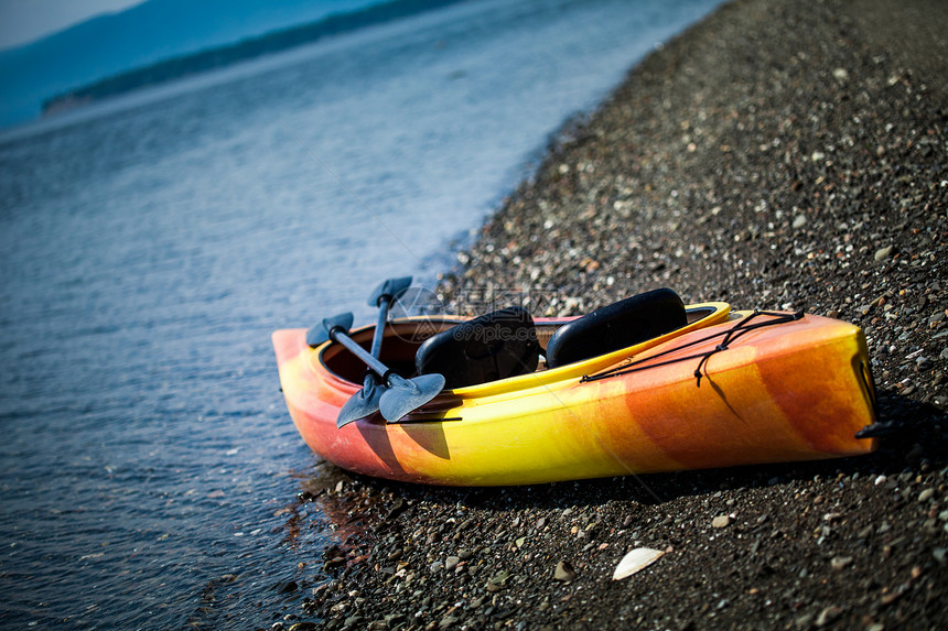橙色和黄色凯亚克 海岸上有乌鸦独木舟冒险活动海滩岩石娱乐海洋运输旅行乐趣图片