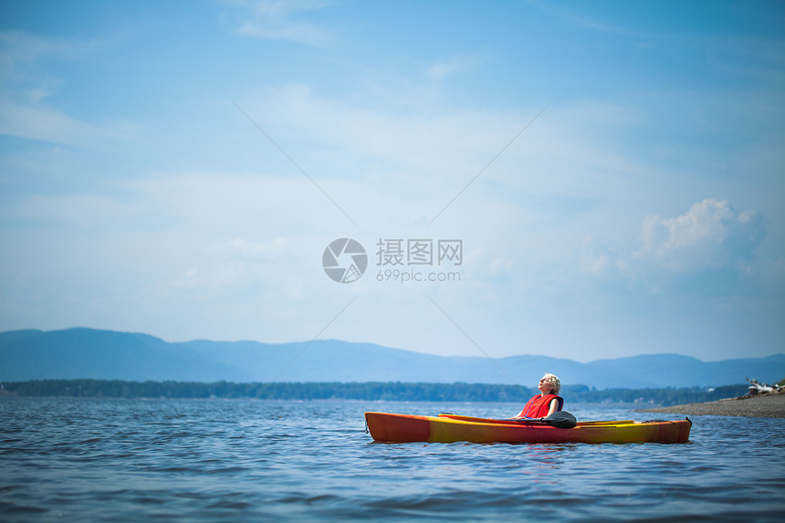 女人在Kayak上放松和享受生活背心救生衣蓝色金发安全旅游女孩乐趣夹克航行图片