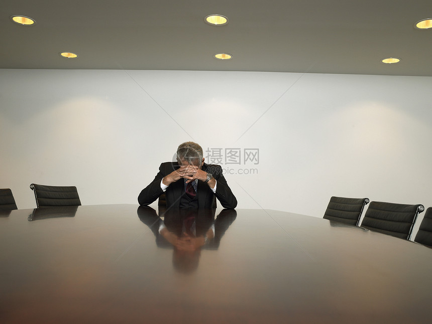 坐在会议室的桌边 手握手拍手的生意人感到紧张图片