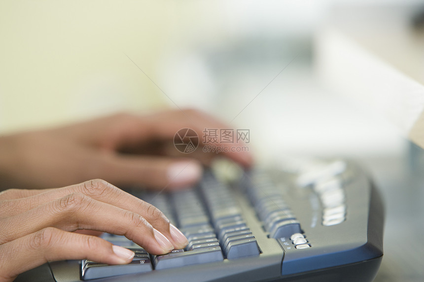 在计算机键盘上打字的妇女手的剪裁图像图片