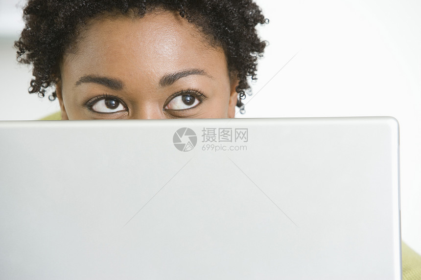 以笔记本电脑向上看的年轻非裔美国妇女图片