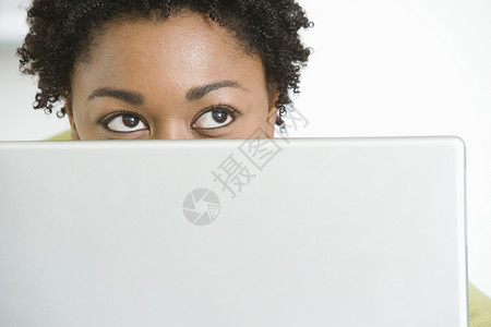 以笔记本电脑向上看的年轻非裔美国妇女背景图片