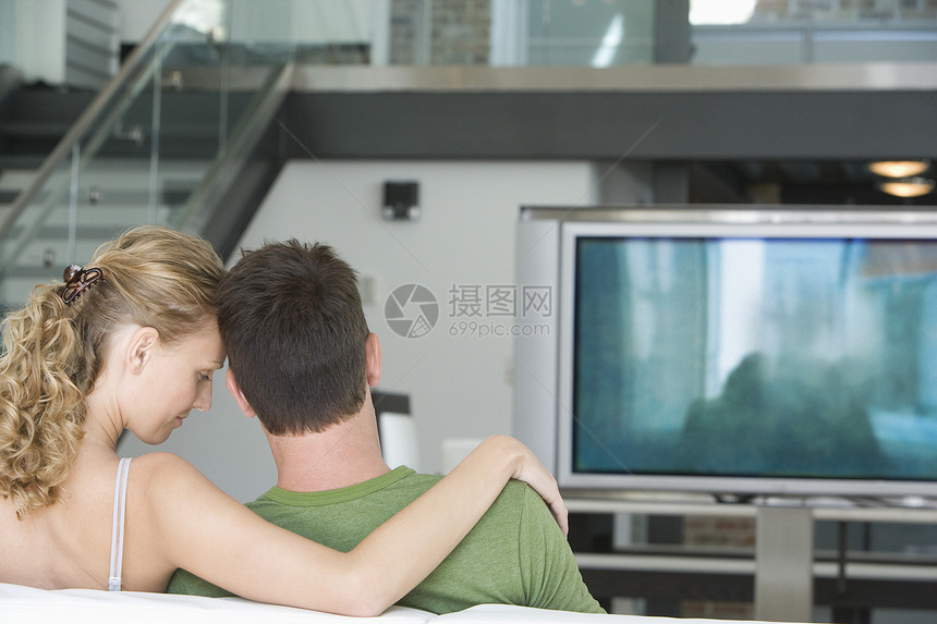 在家看电视的年轻夫妇近视公寓女性水平男人女士成人房子男性电视娱乐图片