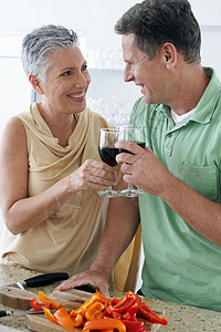 年长夫妇一起站在一起 在厨房举酒杯背景图片